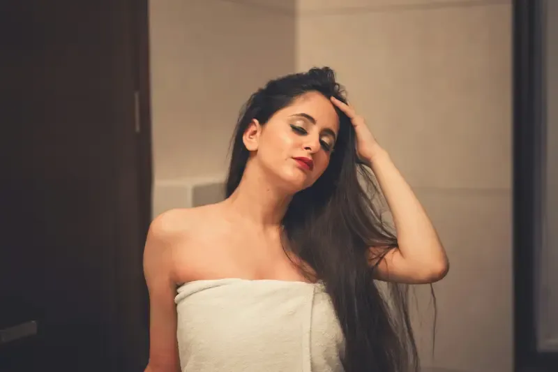 A woman running her hand through soft hair after a shower