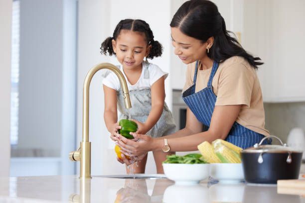 Woman washing vegetables under tap