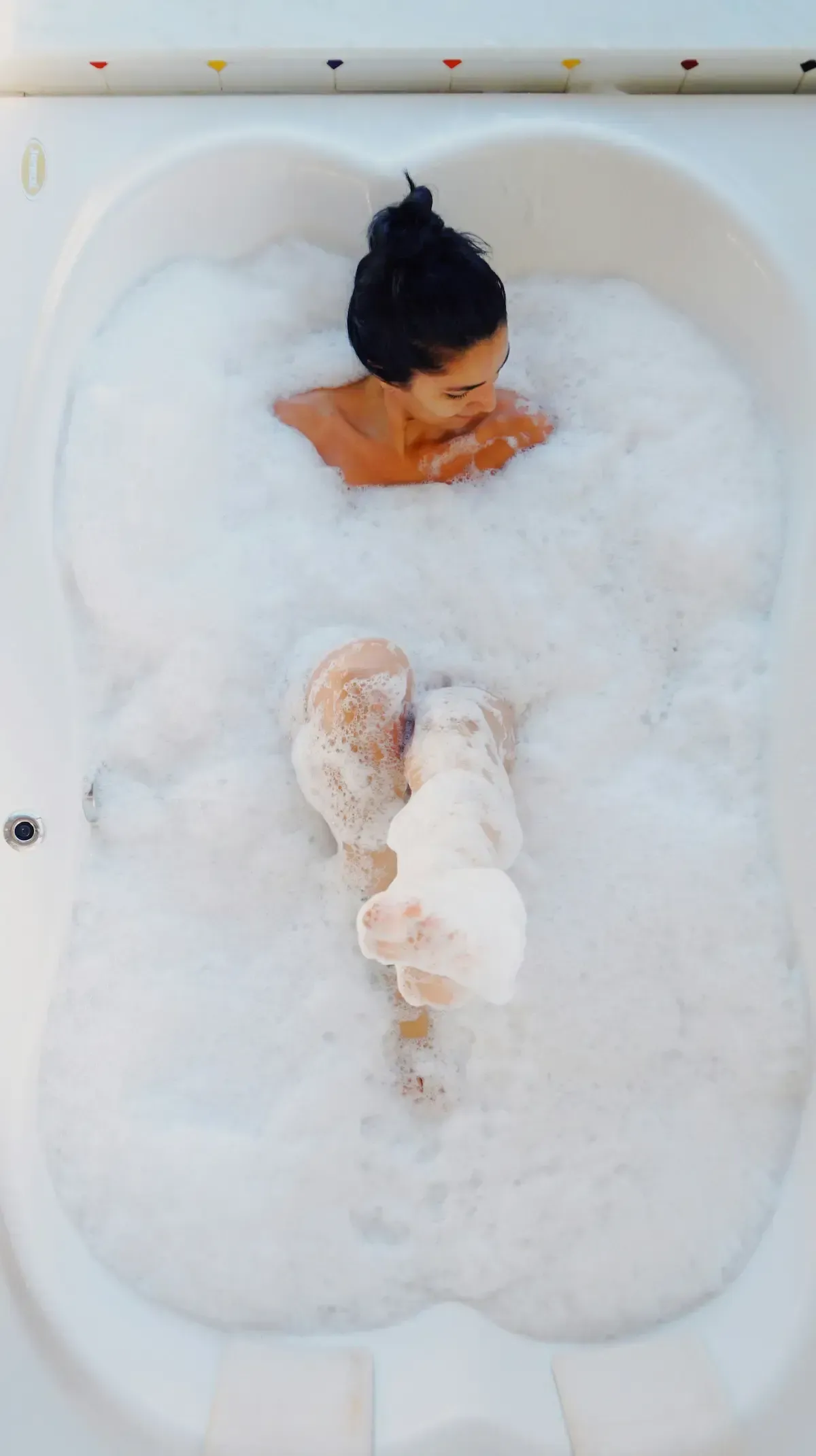 A woman in a very foamy bath